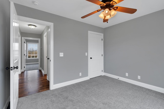 unfurnished bedroom featuring dark colored carpet and ceiling fan