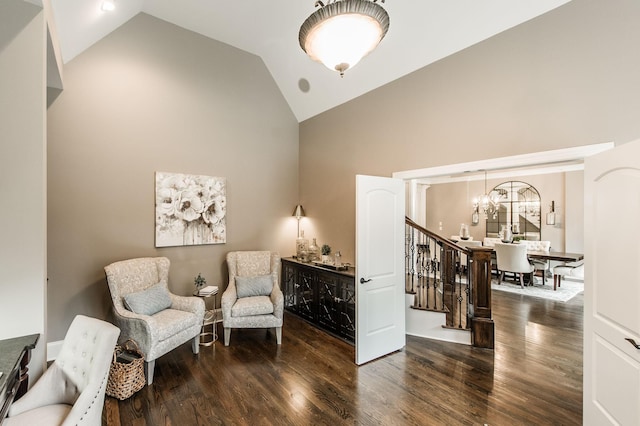 sitting room with dark hardwood / wood-style floors, high vaulted ceiling, and ornate columns