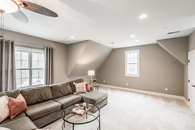 living room featuring ceiling fan, light colored carpet, and lofted ceiling