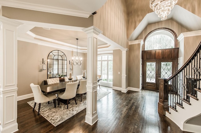 entryway with french doors, crown molding, dark hardwood / wood-style floors, a notable chandelier, and decorative columns