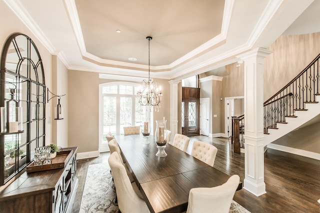 dining space featuring a tray ceiling, dark wood-type flooring, and a healthy amount of sunlight