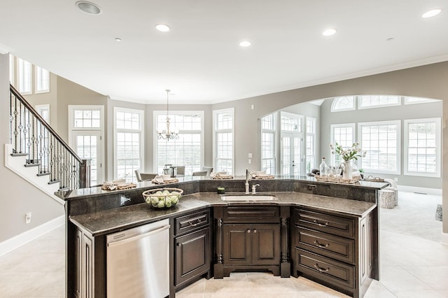 kitchen with dishwasher, a kitchen island with sink, sink, light tile patterned floors, and a notable chandelier