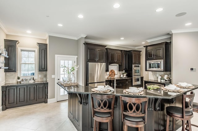 kitchen with a breakfast bar area, dark stone countertops, a large island, and stainless steel appliances