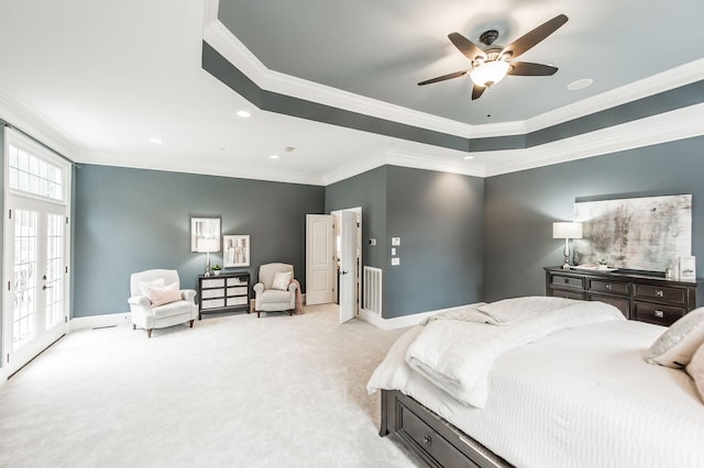 bedroom featuring a tray ceiling, ceiling fan, crown molding, and light carpet