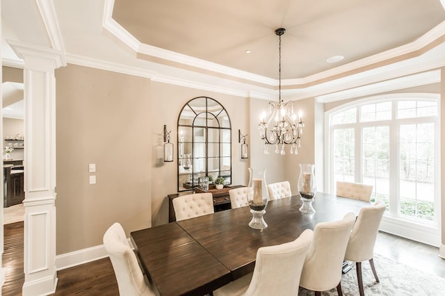 dining area with a raised ceiling, ornamental molding, dark wood-type flooring, and decorative columns