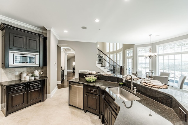 kitchen with an inviting chandelier, sink, ornamental molding, decorative light fixtures, and stainless steel appliances