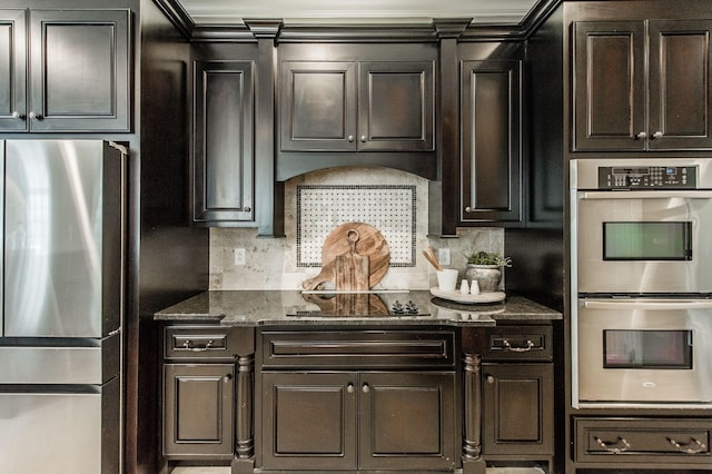 kitchen with dark stone counters, dark brown cabinets, appliances with stainless steel finishes, and tasteful backsplash