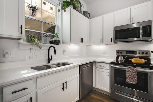 kitchen featuring white cabinetry, sink, dark hardwood / wood-style floors, and appliances with stainless steel finishes