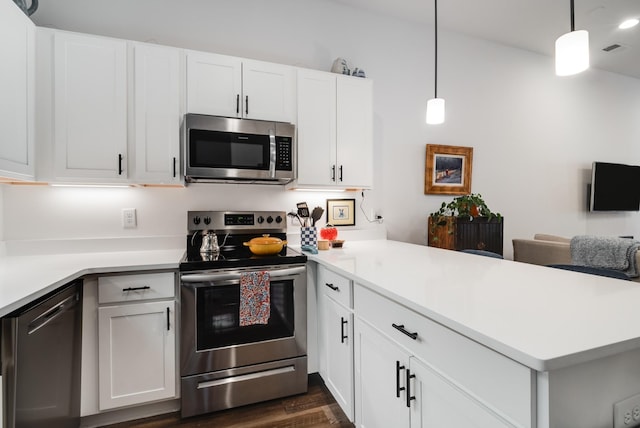 kitchen featuring appliances with stainless steel finishes, dark hardwood / wood-style floors, white cabinetry, and hanging light fixtures