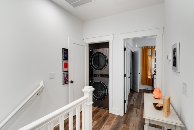 hallway with stacked washer and dryer and dark wood-type flooring