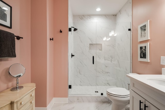 bathroom featuring vanity, toilet, and a shower with door