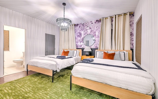 bedroom featuring ensuite bathroom, a chandelier, and hardwood / wood-style flooring