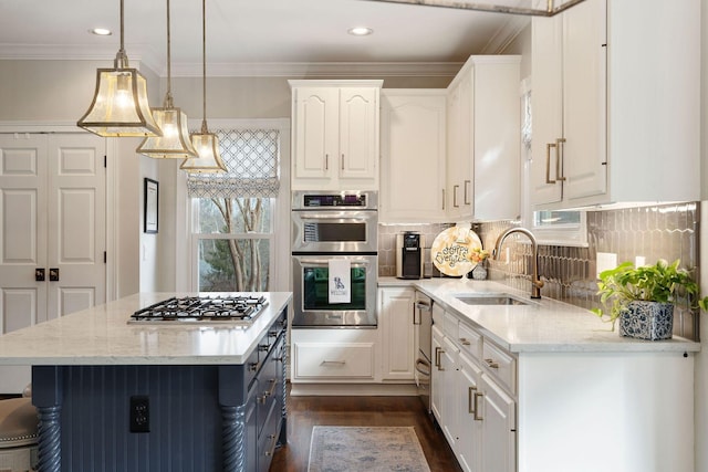 kitchen with light stone countertops, stainless steel appliances, sink, decorative light fixtures, and white cabinetry