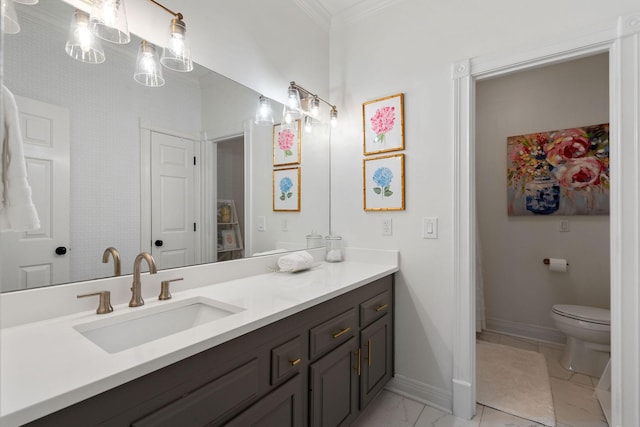 bathroom with toilet, vanity, and ornamental molding