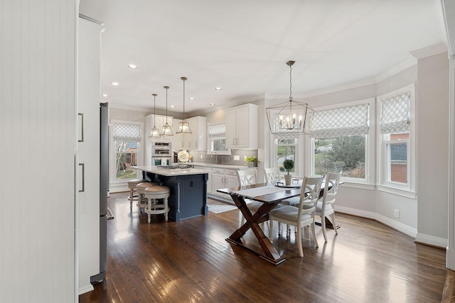 dining area with dark hardwood / wood-style floors, ornamental molding, and sink