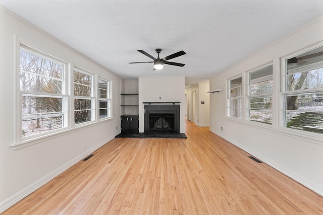 unfurnished living room with ceiling fan, light hardwood / wood-style floors, and built in features