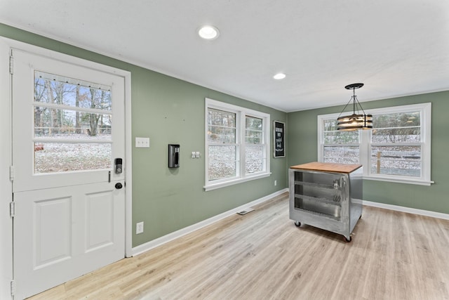 entryway with light hardwood / wood-style floors and a chandelier