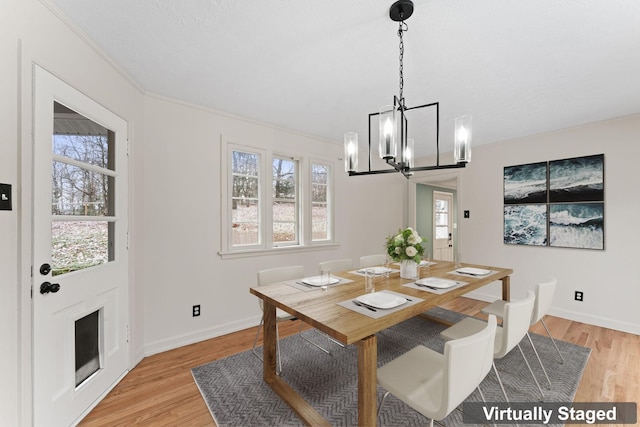 dining area with a notable chandelier, light hardwood / wood-style floors, and a wealth of natural light