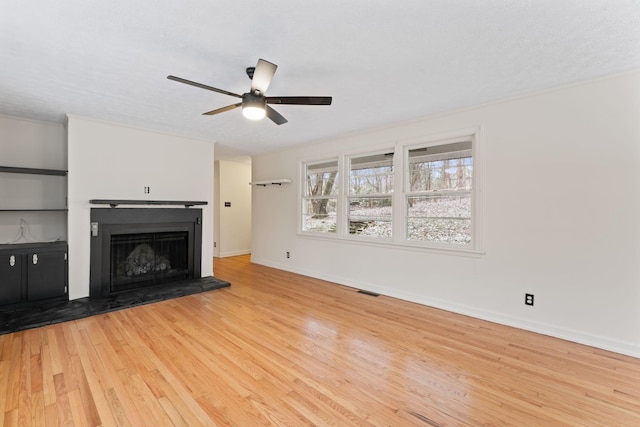 unfurnished living room with a textured ceiling, light wood-type flooring, and ceiling fan