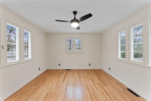 spare room with ceiling fan, plenty of natural light, and light hardwood / wood-style floors