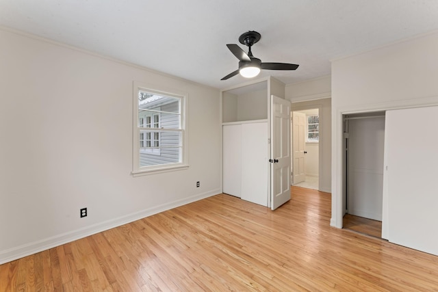 unfurnished bedroom featuring multiple windows, ceiling fan, a closet, and light wood-type flooring