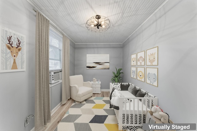 living area featuring light wood-type flooring, cooling unit, and ornamental molding