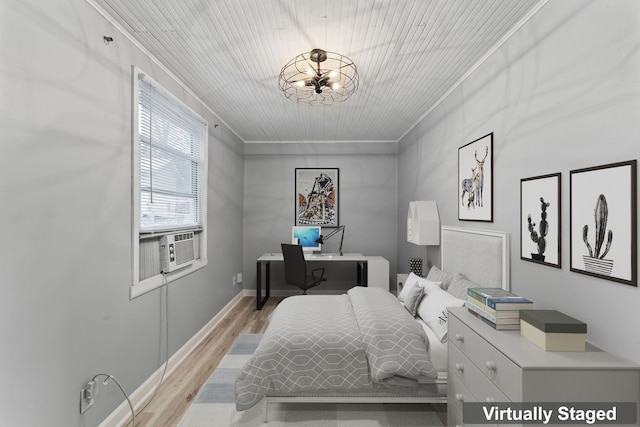 bedroom featuring a notable chandelier, light hardwood / wood-style floors, ornamental molding, and cooling unit