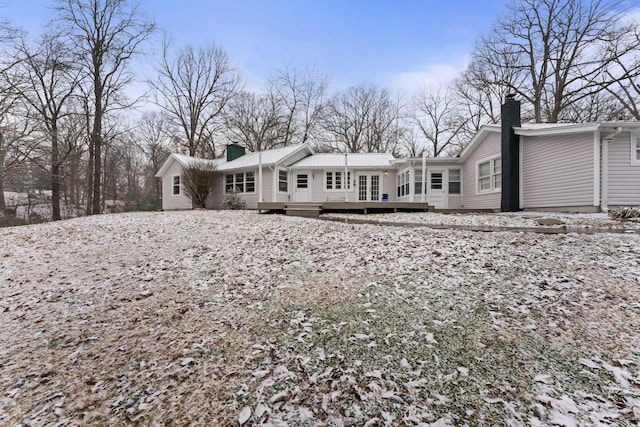 snow covered rear of property featuring a deck