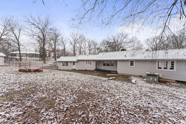 snow covered house featuring central AC unit