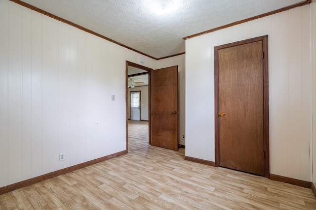 spare room with ceiling fan, crown molding, a textured ceiling, and light hardwood / wood-style flooring