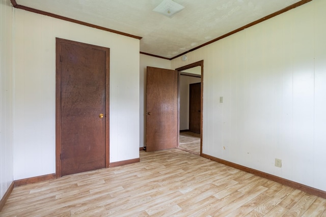 unfurnished bedroom with crown molding and light wood-type flooring