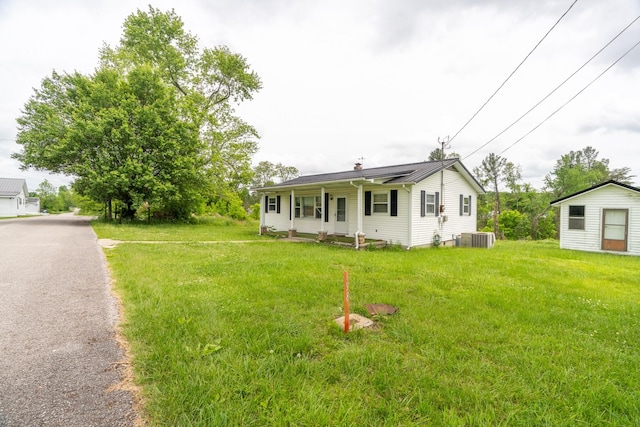 view of front of property with a front lawn, cooling unit, and a porch