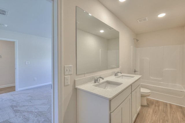 full bathroom featuring shower / bath combination, vanity, hardwood / wood-style floors, and toilet