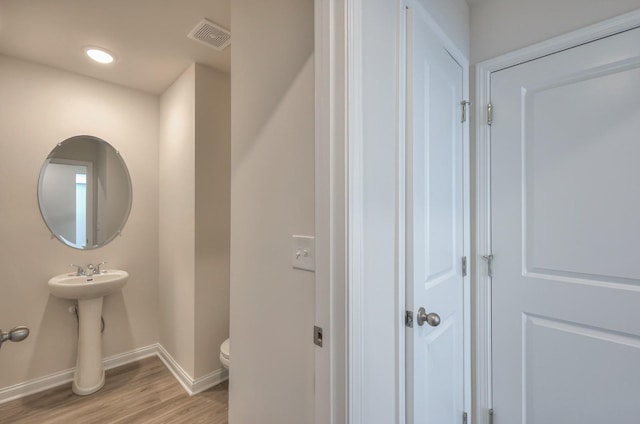 bathroom featuring hardwood / wood-style flooring, toilet, and sink