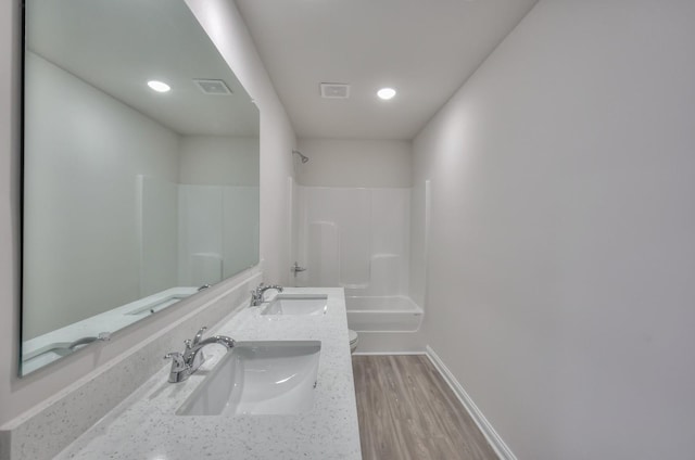 full bathroom with hardwood / wood-style flooring, vanity, bathtub / shower combination, and toilet