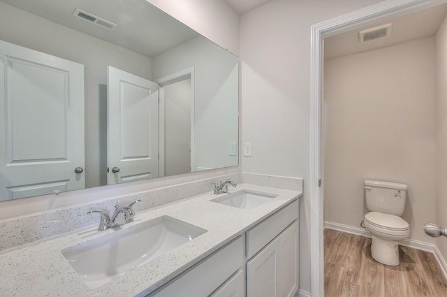 bathroom featuring wood-type flooring, toilet, and vanity