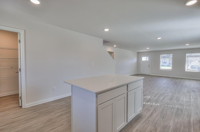 kitchen with a center island, white cabinets, and light hardwood / wood-style floors