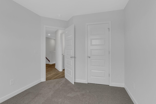 unfurnished bedroom featuring a closet and dark carpet