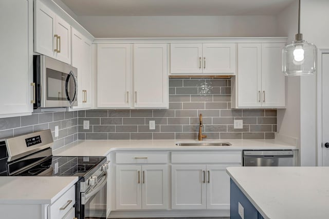 kitchen with pendant lighting, white cabinets, stainless steel appliances, decorative backsplash, and sink