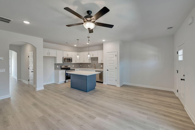 kitchen with ceiling fan, a center island, white cabinetry, light wood-type flooring, and stainless steel appliances