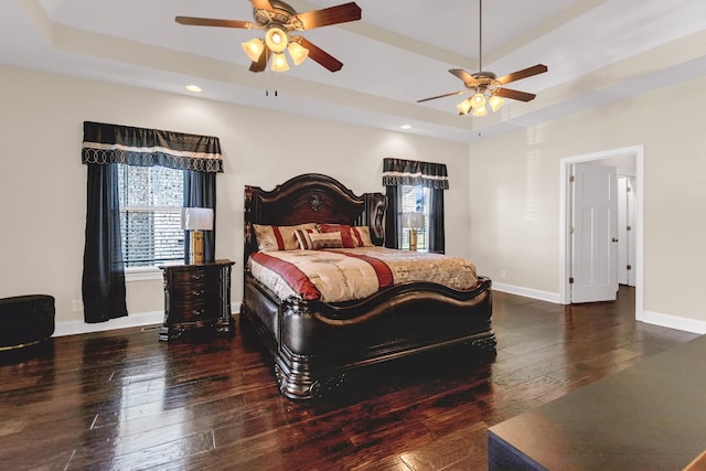 bedroom featuring a ceiling fan, baseboards, recessed lighting, hardwood / wood-style flooring, and a raised ceiling