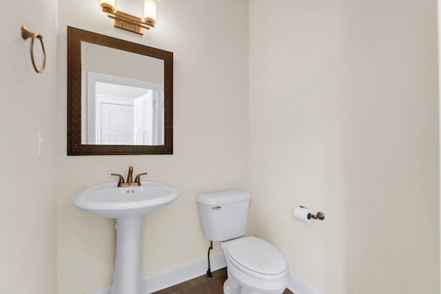 bathroom with tile patterned floors, toilet, baseboards, and a sink