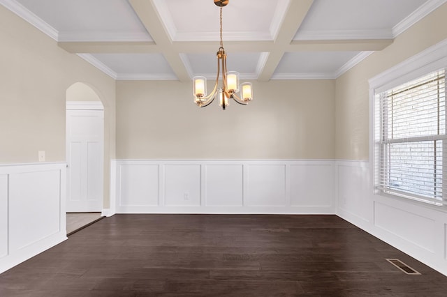 unfurnished room with coffered ceiling, an inviting chandelier, beam ceiling, arched walkways, and dark wood-style flooring