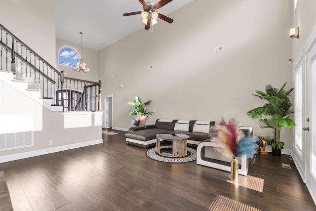 sitting room with stairway, baseboards, a towering ceiling, and wood finished floors