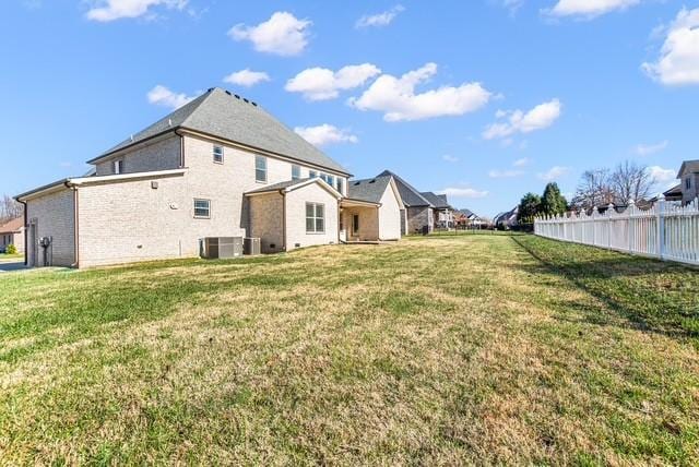 rear view of house with a yard and fence