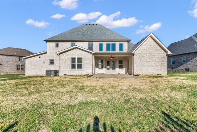 rear view of property with a patio, a yard, and brick siding