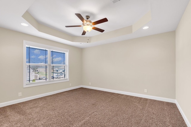 carpeted empty room featuring a tray ceiling, recessed lighting, baseboards, and ceiling fan