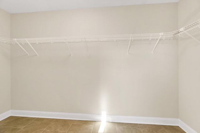 walk in closet with light tile patterned floors