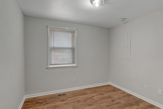 spare room featuring hardwood / wood-style floors and electric panel