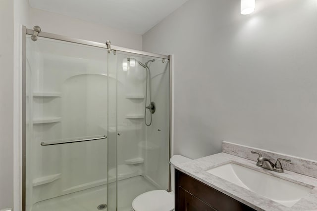 bathroom with vanity, toilet, and a shower with door